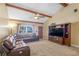 Inviting living room featuring vaulted ceilings, exposed beams, plush seating, and a ceiling fan at 211 Pierce St, Lake Wales, FL 33859