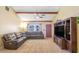 Comfortable living room with beamed ceiling, ceiling fan, large window, and neutral carpet at 211 Pierce St, Lake Wales, FL 33859