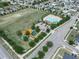 Aerial view of community, pool, playground, and spacious green area at 213 Tanager St, Haines City, FL 33844