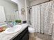 This bathroom features a white countertop, a floral shower curtain and updated fixtures at 213 Tanager St, Haines City, FL 33844