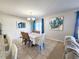 Dining room featuring a lovely table with blue curtains, an adjacent open living area and natural light at 213 Tanager St, Haines City, FL 33844