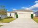 Inviting one-story home with a manicured lawn and a two-car garage, perfect for a cozy Gathering residence at 213 Tanager St, Haines City, FL 33844