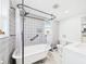 Stylish bathroom with a clawfoot tub, elegant fixtures, and patterned accent wallpaper at 2222 12Th Nw St, Winter Haven, FL 33881