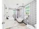 Charming bathroom featuring a clawfoot tub, blue patterned wallpaper, and marble tile floor at 2222 12Th Nw St, Winter Haven, FL 33881