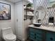 Bathroom vanity with unique vessel sink, stylish mirrors, and tiled accent wall with mounted shelving at 2222 12Th Nw St, Winter Haven, FL 33881