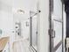 Hallway leading to a bathroom featuring a glass shower and a decorative mirror at 2222 12Th Nw St, Winter Haven, FL 33881