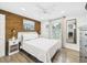 Comfortable bedroom with wood accent wall, ceiling fan, hardwood floors, and natural light from window at 2222 12Th Nw St, Winter Haven, FL 33881