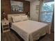 Cozy bedroom with wood accent wall, decorative artwork, and natural light from the window at 2222 12Th Nw St, Winter Haven, FL 33881