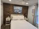 Comfortable bedroom with hardwood accent wall, a queen sized bed, and soft decorative lighting at 2222 12Th Nw St, Winter Haven, FL 33881