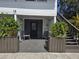 Welcoming entrance with rocking chairs and lush potted plants flanking a dark door and wooden staircase at 2222 12Th Nw St, Winter Haven, FL 33881