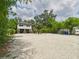 Exterior view of the home featuring a gravel driveway, lush greenery, and a well-maintained yard at 2222 12Th Nw St, Winter Haven, FL 33881