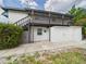 Charming two-story home with a deck and exterior storage units, surrounded by lush greenery at 2222 12Th Nw St, Winter Haven, FL 33881