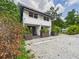 Charming two-story home with a gravel driveway, planter boxes and lush surrounding greenery at 2222 12Th Nw St, Winter Haven, FL 33881