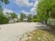 Exterior view of the home featuring a gravel driveway, lush greenery, and a well-maintained yard at 2222 12Th Nw St, Winter Haven, FL 33881