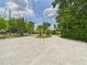 Spacious gravel driveway leading to the home, framed by mature trees and landscaping at 2222 12Th Nw St, Winter Haven, FL 33881