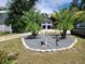 Nicely landscaped front yard featuring dual palm trees in rock garden with white signage post and gray truck in the background at 2222 12Th Nw St, Winter Haven, FL 33881
