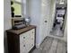 Hallway features wood-look tile and leads to a bedroom visible through a mirror at 2222 12Th Nw St, Winter Haven, FL 33881