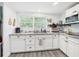 Well-lit kitchen featuring white cabinets, granite countertops, stainless steel appliances, and a view of a window at 2222 12Th Nw St, Winter Haven, FL 33881