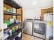 Well-organized laundry room with modern, front-loading washer and dryer and ample storage on black shelving units at 2222 12Th Nw St, Winter Haven, FL 33881