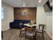 Living room showcasing wood accent wall, blue velvet sofa, and a dining table with four chairs at 2222 12Th Nw St, Winter Haven, FL 33881