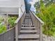 Outdoor staircase with stained wood, surrounded by lush greenery and tropical plants at 2222 12Th Nw St, Winter Haven, FL 33881