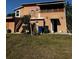 Exterior of home features upper enclosed porch, stairs and access to a grassy backyard at 229 Ne Avenue B, Winter Haven, FL 33881