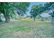 Spacious backyard surrounded by mature trees, ideal for outdoor activities and enjoying the tranquility of nature at 230 Denton Ave, Auburndale, FL 33823