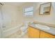Clean bathroom featuring a shower-tub combo, toilet, vanity with a sink, and a framed mirror at 230 Denton Ave, Auburndale, FL 33823