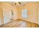 Inviting bedroom with luxury vinyl plank flooring, neutral walls, window with curtains, and a closet for storage at 230 Denton Ave, Auburndale, FL 33823