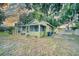 Charming cottage-style home featuring a cozy screened porch and verdant landscaping at 230 Denton Ave, Auburndale, FL 33823