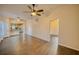 Spacious living room with wood-look floors, ceiling fans, and open access to kitchen and bedrooms at 230 Denton Ave, Auburndale, FL 33823
