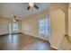 Spacious living room featuring hardwood floors, a ceiling fan, and a large window that provides ample natural light at 230 Denton Ave, Auburndale, FL 33823