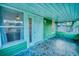Inviting front porch with unique mosaic tile flooring and ample natural light at 230 Denton Ave, Auburndale, FL 33823
