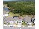 Aerial view of a home with a brick driveway, red shutters and a nearby pond surrounded by lush greenery at 2356 Palm Park Loop, Clermont, FL 34714
