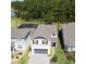 Aerial view showcasing a home with a brick driveway, red shutters and views of a pond surrounded by greenery at 2356 Palm Park Loop, Clermont, FL 34714