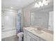 Clean bathroom featuring tub-shower combination, bright lighting, and a vanity with white cabinetry at 2356 Palm Park Loop, Clermont, FL 34714