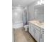 Well-lit bathroom featuring white cabinets, quartz countertops, tile flooring, and tub-shower combination at 2356 Palm Park Loop, Clermont, FL 34714