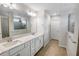 Bright bathroom features double sinks, white cabinetry, tile floors, and glass shower at 2356 Palm Park Loop, Clermont, FL 34714