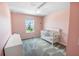Bright bedroom features soft pink walls, ceiling fan, plush gray carpeting and a white baby crib at 2356 Palm Park Loop, Clermont, FL 34714