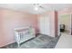 Bright bedroom boasts soft pink walls, closet with white bi-fold doors and plush gray carpeting at 2356 Palm Park Loop, Clermont, FL 34714