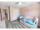 Bedroom features soft pink walls, a ceiling fan, and carpeted floors at 2356 Palm Park Loop, Clermont, FL 34714