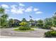 Community center entrance featuring lush landscaping, palm trees and an American flag on a clear day at 2356 Palm Park Loop, Clermont, FL 34714