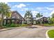 Elegant community center with lush landscaping, palm trees, and a paved walkway on a sunny day at 2356 Palm Park Loop, Clermont, FL 34714