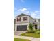 Beautiful two-story home featuring gray siding, a brick driveway, red shutters, and neatly arranged landscaping at 2356 Palm Park Loop, Clermont, FL 34714