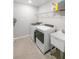 Modern laundry room with tile flooring, washer and dryer, sink and wire shelving at 2356 Palm Park Loop, Clermont, FL 34714