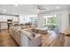 Open-concept living room with a spacious sectional sofa, blending seamlessly into the modern kitchen and outdoor patio at 2356 Palm Park Loop, Clermont, FL 34714