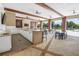 Outdoor kitchen and dining area with ample seating and a large screen TV on a sunny day at 2356 Palm Park Loop, Clermont, FL 34714