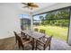 Screened lanai with a wood table and seating with a view of the lush backyard and pool at 2356 Palm Park Loop, Clermont, FL 34714