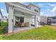 Covered patio with outdoor dining set and a grill, perfect for entertaining guests in the backyard at 2356 Palm Park Loop, Clermont, FL 34714