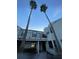 Charming condominium with a balcony and well-maintained siding and two tall palm trees in the front at 2516 Woodgate Blvd # 205, Orlando, FL 32822